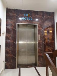 a elevator in a hotel with a sign on the wall at FKI INTERNATIONAL HOTEL in Kuala Lumpur