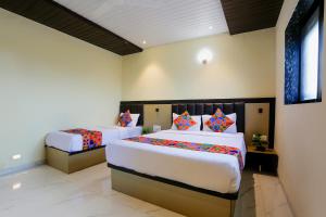 sypialnia z 2 łóżkami w pokoju w obiekcie FabExpress Prime Land w Bombaju