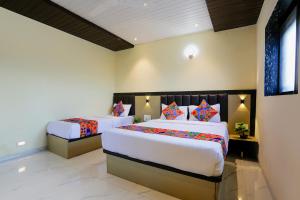 sypialnia z 2 łóżkami w pokoju w obiekcie FabExpress Prime Land w Bombaju