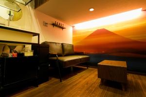 a room with a couch and a picture of a mountain at MoonlightVilla 河口湖大橋 in Fujikawaguchiko