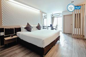 een slaapkamer met een groot bed en een tafel bij Three Sukhumvit Hotel - SHA Plus Certified in Bangkok