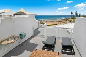 a balcony with chairs and a view of the beach at Grand Palais Boolarong Beachside Apartments in Alexandra Headland