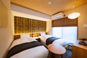a hotel room with two beds and a window at Rinn Gion Kenninji in Kyoto