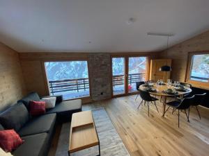 ein Wohnzimmer mit einem Sofa und einem Tisch in der Unterkunft Chalet TALBLICK - Luxurious Penthouse on the 1st floor! in Saas-Fee