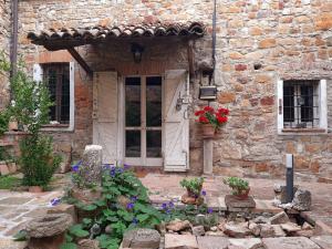 Montalbo的住宿－Casa Morelli，门前有鲜花的石头房子