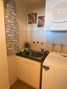 a small kitchen with a sink and a refrigerator at Wirrina Cove Apartment in Wirrina Cove