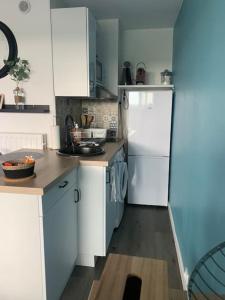 a kitchen with white cabinets and a white refrigerator at Chaleureux appartement face au Port Sta Lucia, tout à pieds, wifi in Saint-Raphaël