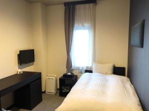 Habitación de hotel con cama y ventana en HOTEL COLLECT, en Sakai