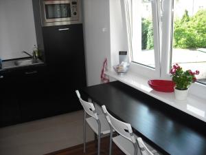 a kitchen with a black counter and a window at Pokoje w Apartamencie Danuta in Gdynia