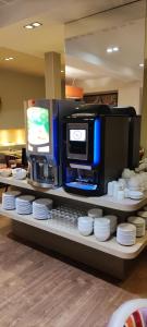 a counter with a coffee machine and white plates at Hotel de la Gare Troyes Centre in Troyes