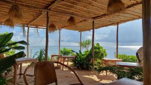 un ristorante con tavoli e sedie sulla spiaggia di Mtende Beach Bungalow océan view a Mtende