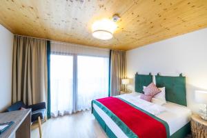 a bedroom with a large bed with a green headboard at Genuss-Pension Herti in Übelbach