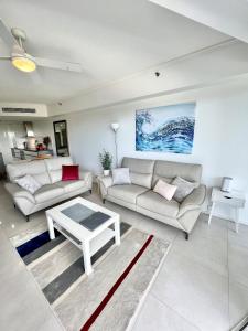 a living room with two couches and a table at Sebel 302 - Deluxe Apartment in Maroochydore