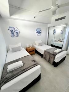 馬盧奇多的住宿－Sebel 302 - Deluxe Apartment，一间卧室配有两张床和镜子