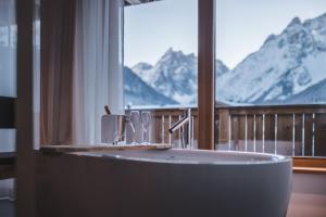 Cette chambre dispose d'une baignoire et offre une vue sur les montagnes. dans l'établissement Schuischta Mountain Apartments, à Sesto