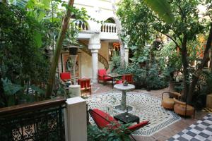 a patio with chairs and a table in a garden at Riad Malika in Marrakesh