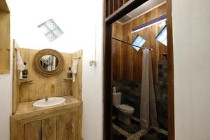 a bathroom with a sink and a toilet and a mirror at Wood Stone in Yogyakarta