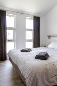 1 dormitorio con 1 cama con 2 toallas en luxe cottage knokke heist en Knokke-Heist