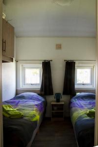 two beds in a room with two windows at luxe cottage knokke heist in Knokke-Heist