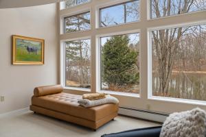 sala de estar con sofá y ventanas grandes en River House in the Heart of Middlebury en Middlebury