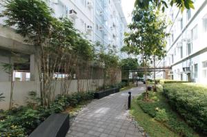 a sidewalk in front of a building with trees at Jamah's Staycation at SMDC Trees Residences by RedDoorz in Manila