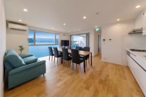 a kitchen and living room with a table and chairs at SEASIDE TERRACE SUN in Enoura