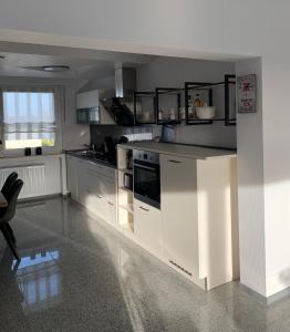 uma cozinha com armários brancos e um forno com placa de fogão em Ruhrpott-Liebe em Bottrop