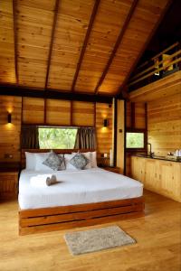 1 dormitorio con 1 cama en una habitación con paredes de madera en Riverbank Resort Gampola, en Gampola