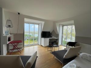 a living room with a couch and a tv at Hôtel - Spa Les Corderies in Saint-Valéry-sur-Somme