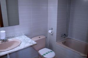 a bathroom with a toilet and a sink and a tub at Suite Apartments Arquus in Salou