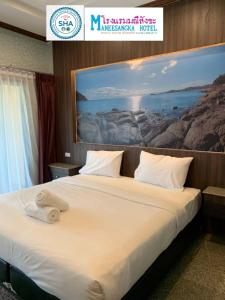 une chambre d'hôtel avec un lit orné d'une peinture murale. dans l'établissement โรงแรมมณีสังขะ, à Sangkha