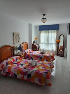 sypialnia z dwoma łóżkami i lustrem w obiekcie Pension A Barca w mieście O Barco de Valdeorras