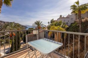 Un balcón con mesa y vista al mar. en Villa Fuentes, en Almuñécar