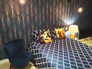 una camera con letto e sedia blu di Studio Chaleureux a Pont-sur-Seine