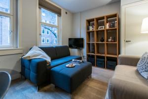 a living room with a blue couch and a stool at Two-bedroom Apartment in Amsterdam West in Amsterdam