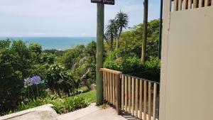 a porch with a street sign and the ocean at Ocean Rush Dolphin in Zinkwazi Beach