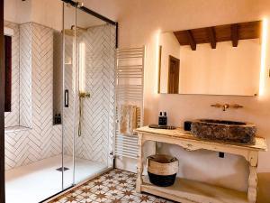 a bathroom with a glass shower and a sink at EL CUENTO DE LA ENCINA. Un espacio para sentir in Majaelrayo