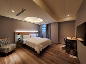 sypialnia z łóżkiem, biurkiem i telewizorem w obiekcie HINOEN Hotel w Tajpej