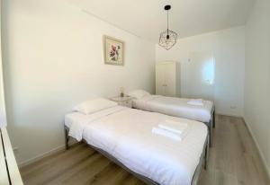twee bedden in een kamer met witte muren en houten vloeren bij Witte Jade in Egmond aan den Hoef