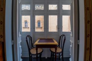 a table and two chairs in front of a window at Monreal Boutique Townhouse - R024RM2 in Paola