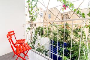 un fauteuil rouge installé au-dessus du balcon dans l'établissement Monreal Boutique Townhouse - R024RM2, à Paola