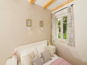 a white bedroom with a bed and a window at Aldo Apartments Center in Zadar