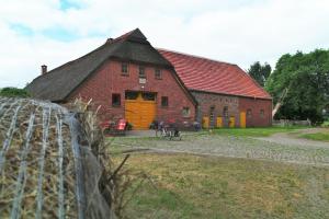 een groot gebouw van rode baksteen met een gele deur bij Schäfchenwolke in Worpswede