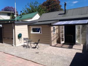 a building with a table and chairs in front of it at Milton Cottage in Napier
