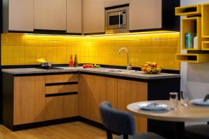 a kitchen with a sink and a table at Citadines City Centre Tbilisi Apart`hotel in Tbilisi City