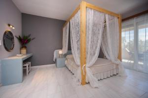 a bedroom with a canopy bed with a window at Sunset Apartments in Archangelos