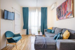 - un salon avec un canapé gris et une chaise dans l'établissement BpR Blue Paradise Apartment with A/C, à Budapest