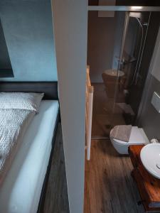 uma casa de banho com uma cama, um lavatório e um WC. em Stalder Meat & Bed em Muralto