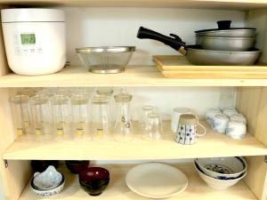 a shelf with many glass jars and a mixer at Harimayabashi Guesthouse in Kochi