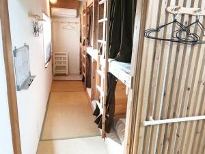 einen Flur in einem Wohnwagen mit einem Flur, der in ein Zimmer führt in der Unterkunft Harimayabashi Guesthouse in Kōchi